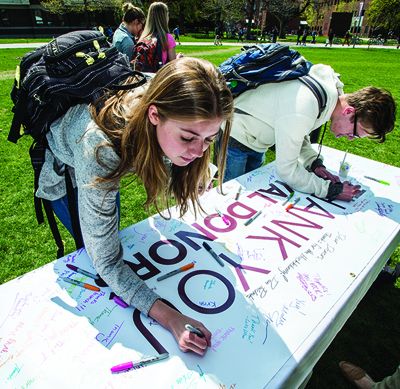 Students sign thank-you banners for donors.